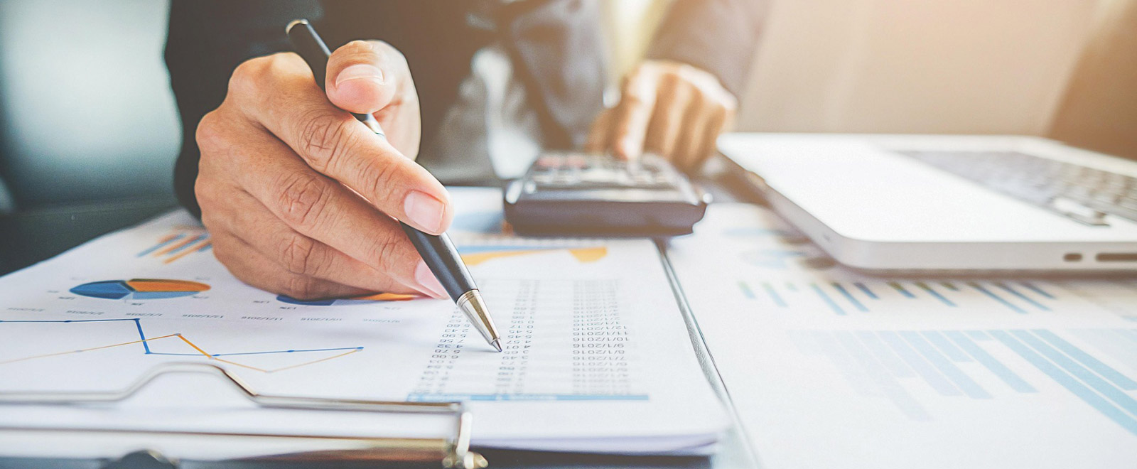 person with calculator looking over numbers